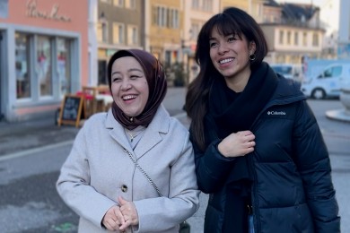 Zwei Frauen, die lachend gemeinsam durch die Stadt laufen 