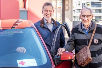 Ein freiwilliger Fahrer begleitet einen älteren Mann zu einem medizinischen Termin.