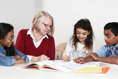 Freiwillige hilft Gastkindern bei den Hausaufgaben