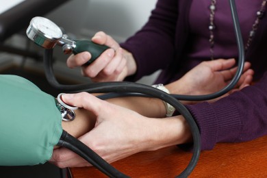 Ärztin misst Blutdruck von Sans-Papiers Patientin