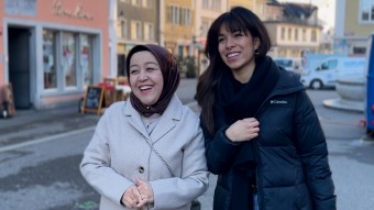Zwei Frauen, die lachend gemeinsam durch die Stadt laufen 