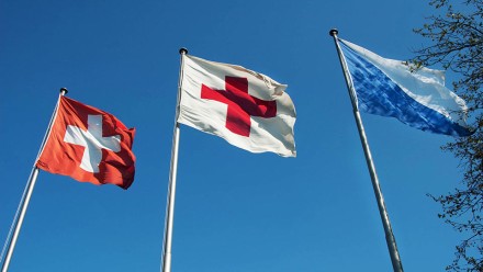 Eine Fahne der Schweiz, des Roten Kreuzes und des Kantons Zürich 