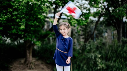 Kind hält die Fahne des Roten Kreuzes hoch an einem Anlass im Zoo Zürich.