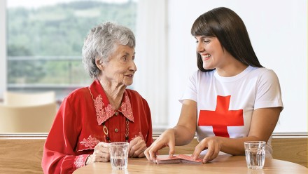 Eine Jugendrotkreuz-Freiwillige und eine Bewohnerin aus einem Zürcher Alterszentrum spielen zusammen Karten.