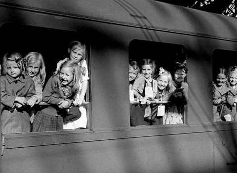 Zugkinder, die zur Erholung in die Schweiz reisten, schauen aus dem Zugfenster