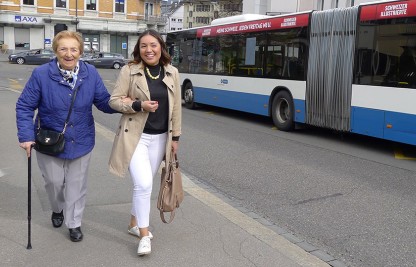 Freiwillige begleitet ältere Frau zum Bus